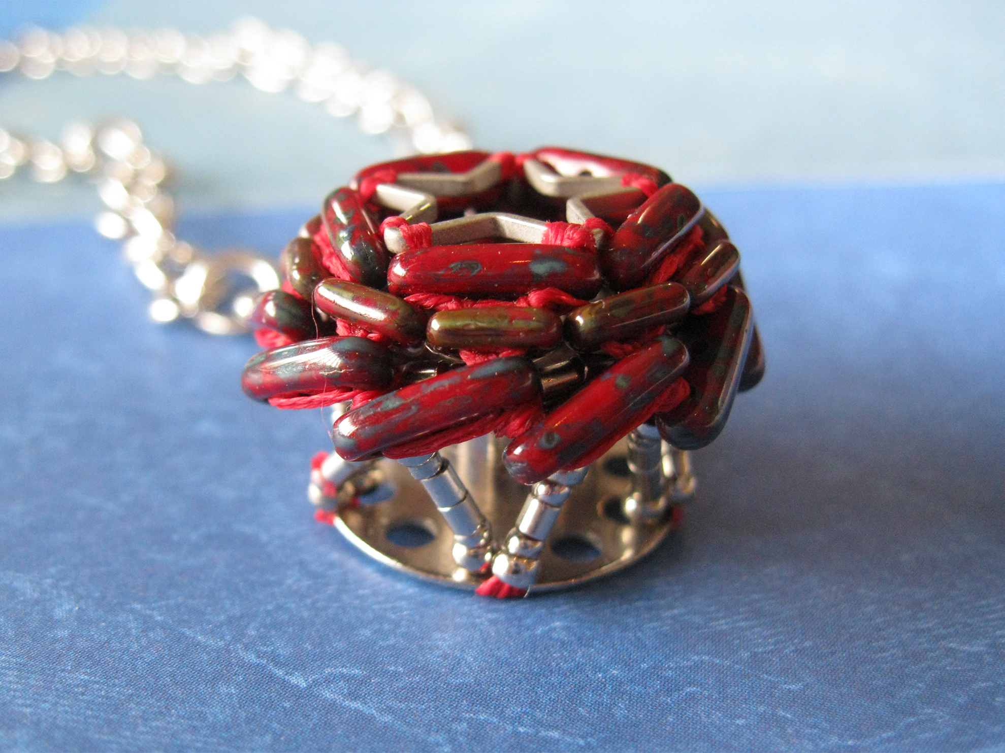 Beaded bobbin necklace featuring red picasso beads circling a star