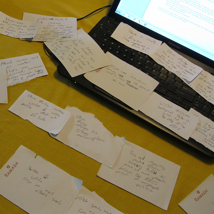 flashcards spread on table and laptop; printed and handwritten pages of stories