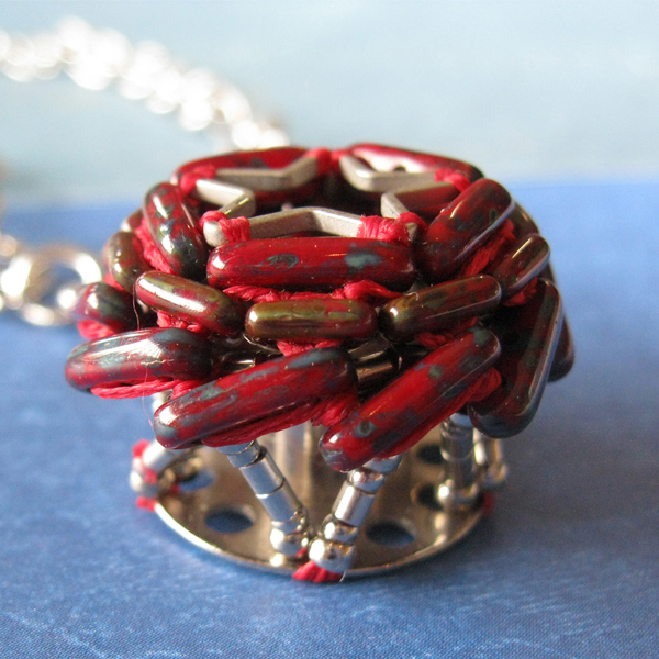 Necklace bobbin pendant with red picasso beads encircling a star
