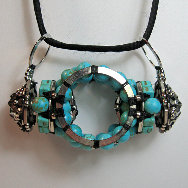Beaded necklace with square and round magnesite and turquoise beads woven into a cylindrical shape, with more bobbins woven on a bobbin on either side