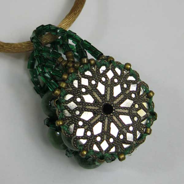 Beaded pendant of a bobbin covered in a latticework of brass and green glass beads