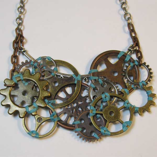 Steampunk necklace made of a cluster of overlapping decorative cogs of varying sizes, bond together with aqua beadstring