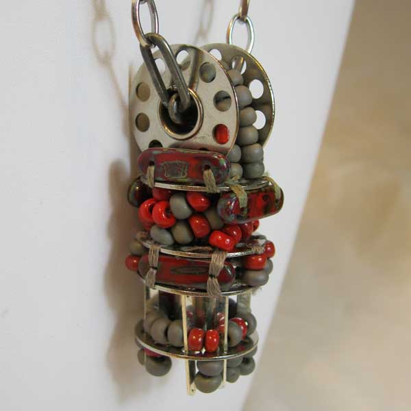 Dangling beaded pendant witih tiers of bobbins, gray and red glass beads, and red picasso beads