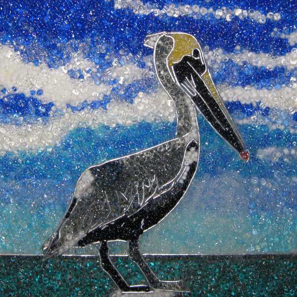 Bead painting of a pelican on a stoop in front of a body of water and open sky
